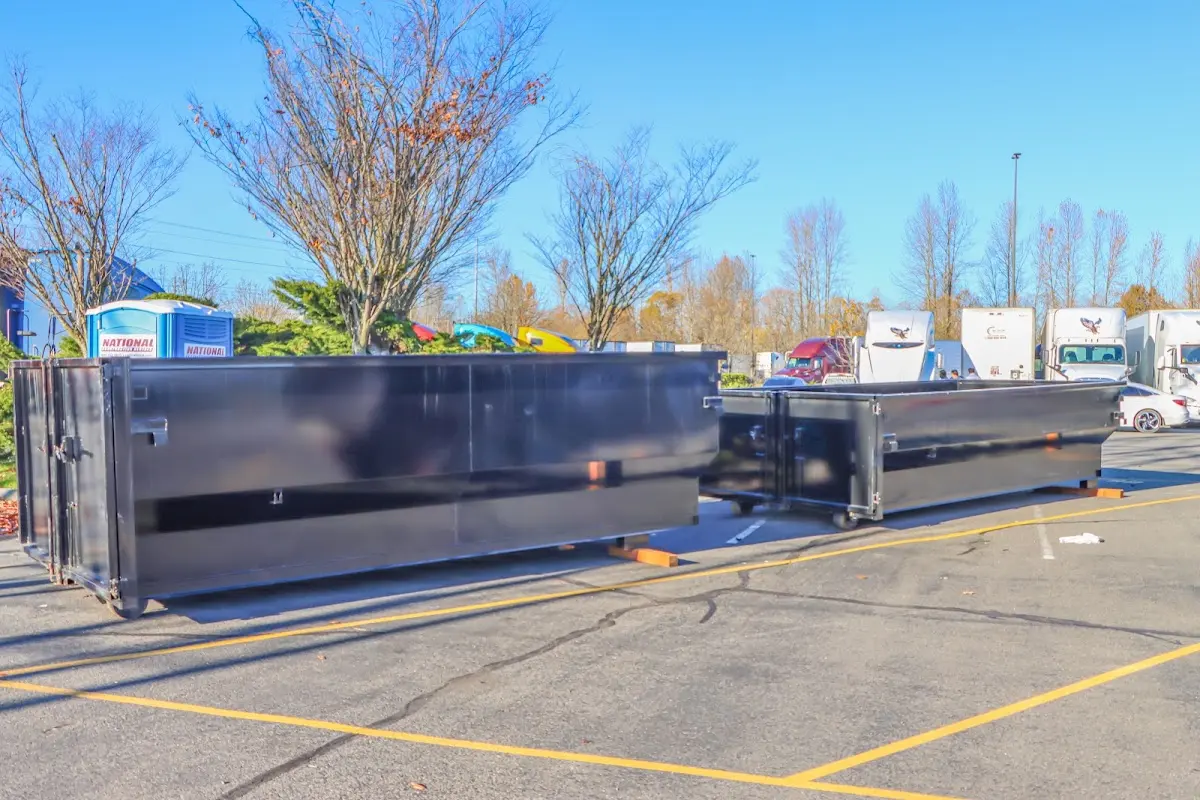 Professional dumpster rental service with roll-off container on residential driveway in McCalla